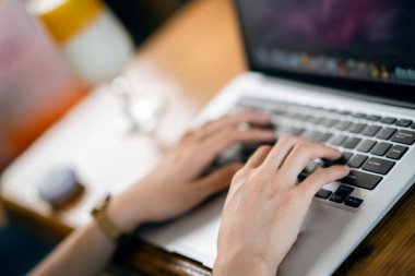 Kız kahve odasındaki dizüstü bilgisayarı kullanıyor.