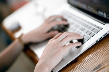 Kız kahve odasındaki dizüstü bilgisayarı kullanıyor.