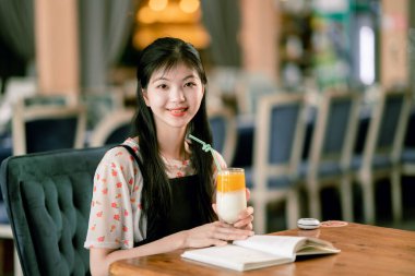 Kız kahve dükkanında okuyor.