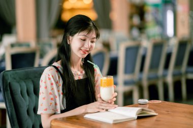 Kız kahve dükkanında okuyor.