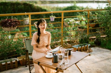 Kız bahçede kitap okuyor.