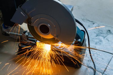 Metal kesme testeresi bir atölyenin her yerine kıvılcım saçar.