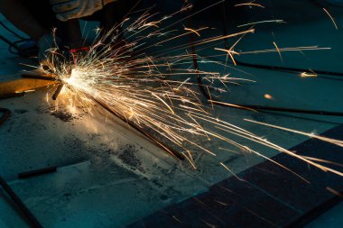 Metal kesme testeresi bir atölyenin her yerine kıvılcım saçar.