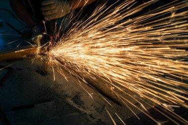 Metal kesme testeresi bir atölyenin her yerine kıvılcım saçar.