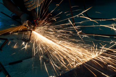 Metal kesme testeresi bir atölyenin her yerine kıvılcım saçar.