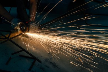 Metal kesme testeresi bir atölyenin her yerine kıvılcım saçar.