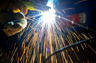 bir fabrikada kaynak koruyucu maske ile genç adam