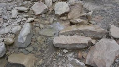 Su küçük bir derede kayaların üzerinden akıyor. Kamera kilitlendi. Sesle..