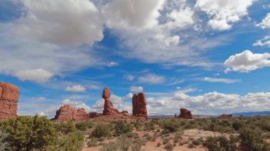 Arches Ulusal Parkı 'nda bir zaman çizelgesi. Dengeli Kaya oluşumu ön planda, kamera sağa doğru hareket ederken, bulutlar sola doğru hareket ediyor..