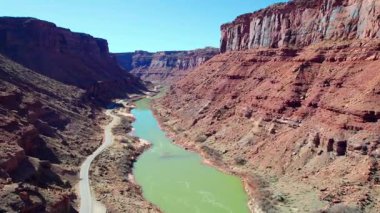 Colorado Nehri 'nin her iki tarafında da kaya oluşumları olan bir kanyon boyunca akan havadan görüntüsü. Nehre paralel bir yol var..
