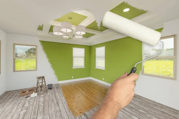 新鮮な緑の塗料で新しい改装された部屋を明らかにするためにペイントローラーを使用して男の前と後 Coffed天井と新しい床 — ストック写真