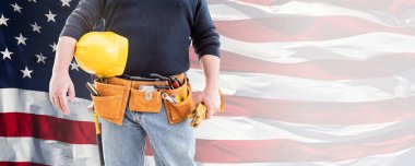 Erkek Müteahhit Alet Kemeri Giyiyor ve Boş Sarı Şapka Tutuyor ve Amerikan Bayrağı Üzerinde Eldivenler.