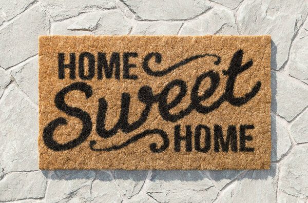 Overhead of Home Sweet Home doormat on the rock tile porch.