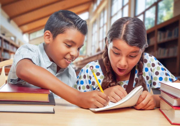 图书馆里的两个西班牙裔学童对自己的家庭作业感到兴奋 — 图库照片#