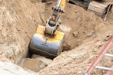 Çalışan Kazıcı Traktörü İnşaat Alanında Hendek Kazıyor.