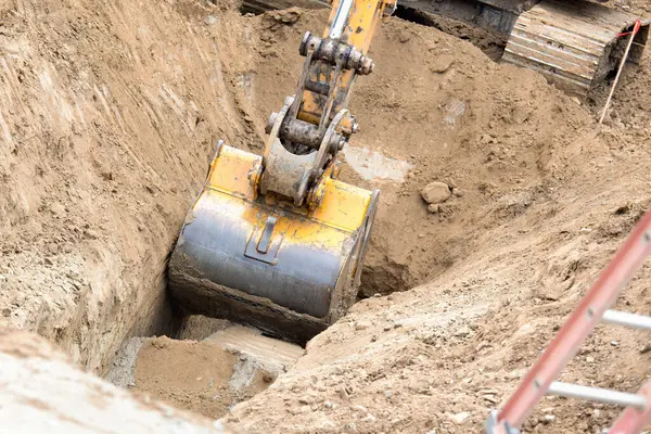 Çalışan Kazıcı Traktörü İnşaat Alanında Hendek Kazıyor.