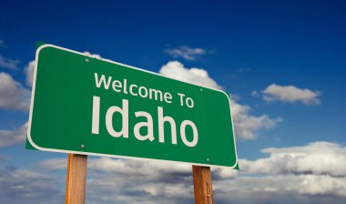 Idaho 'ya hoş geldiniz. Mavi Gökyüzü üzerinde Bulutlu Yeşil Yol tabelası..