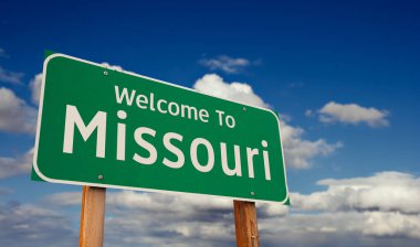 Missouri 'ye hoş geldiniz. Mavi Gökyüzü üzerinde Bulutlu Yeşil Yol tabelası..