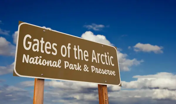 stock image Gates of the Arctic National Park & Preserve (Alaska) Road Sign Against Blue Sky and Clouds.