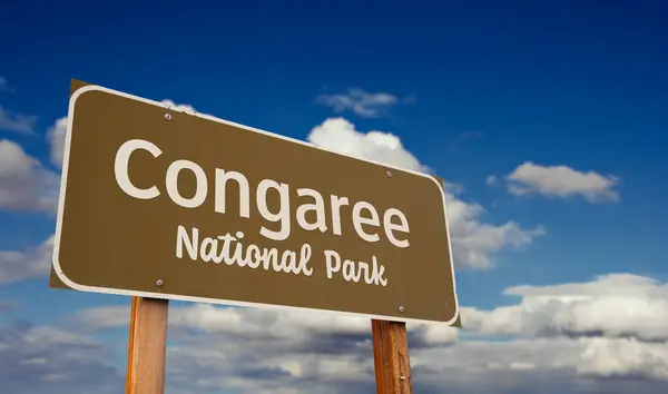 stock image Congaree National Park (South Carolina) Road Sign Against Blue Sky and Clouds.