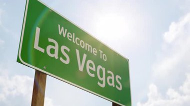 4k Las Vegas 'a hoş geldiniz Yeşil Yol İşareti ve İniş takımları ile alçaktan uçan uçak.