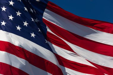 American Flag Waving In The Wind Against Deep Blue Sky.