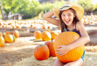 Kovboy Şapkası Giyen Güzel Kız Güneşli Sonbahar Gününde Balkabağı Tarlasının Tadını Çıkartıyor.