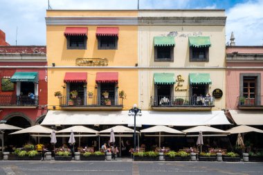 PUEBLA, MEXICO - 10 AĞUSTOS 2024: Puebla 'nın tarihi merkezinde renkli eski bir binadaki restoranlar