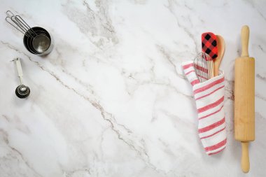Yuvarlanan iğne, çay havlusu, spatula, tahta kaşık, çırpı, mermer zemin üzerinde mermer fincanlar ve kaşıklar düz konumda. metin için yer var.