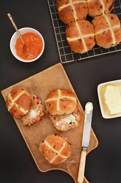 新烘烤的热交叉面包在黑色背景上的平面平铺组成垂直格式 传统复活节食品 — 图库照片
