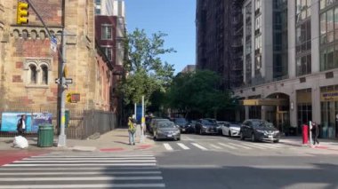 New York 'ta Doğu 66. Cadde' nin kesiştiği yerde kimliği belirsiz insanlar ve sokak trafiği var.