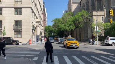 New York 'ta Doğu 66. Cadde' nin kesiştiği yerde kimliği belirsiz insanlar ve sokak trafiği var.