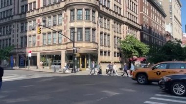 New York 'ta Doğu 66. Cadde' nin kesiştiği yerde kimliği belirsiz insanlar ve sokak trafiği var.