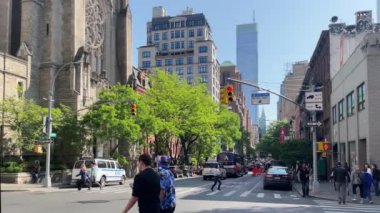 New York 'ta Doğu 66. Cadde' nin kesiştiği yerde kimliği belirsiz insanlar ve sokak trafiği var.