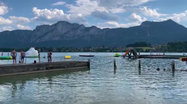 Mondsee, Yukarı Avusturya, 25 Haziran 2024: Ziyaretçiler, Mondsee kasabasındaki popüler bir göl kenti olan Alpenseebad Mondsee 'de güneşli bir yaz gününün tadını çıkarıyorlar
