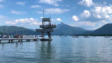 Mondsee, Yukarı Avusturya, 25 Haziran 2024: Ziyaretçiler, Mondsee kasabasındaki popüler bir göl kenti olan Alpenseebad Mondsee 'de güneşli bir yaz gününün tadını çıkarıyorlar