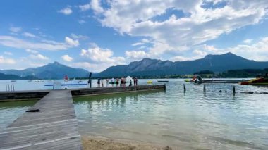 Mondsee, Yukarı Avusturya, 25 Haziran 2024: Ziyaretçiler, Mondsee kasabasındaki popüler bir göl kenti olan Alpenseebad Mondsee 'de güneşli bir yaz gününün tadını çıkarıyorlar