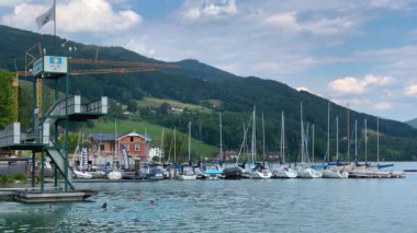 Mondsee, Yukarı Avusturya, 25 Haziran 2024: Ziyaretçiler, Mondsee kasabasındaki popüler bir göl kenti olan Alpenseebad Mondsee 'de güneşli bir yaz gününün tadını çıkarıyorlar