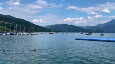 Mondsee, Yukarı Avusturya, 25 Haziran 2024: Ziyaretçiler, Mondsee kasabasındaki popüler bir göl kenti olan Alpenseebad Mondsee 'de güneşli bir yaz gününün tadını çıkarıyorlar