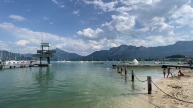 Mondsee, Yukarı Avusturya, 25 Haziran 2024: Ziyaretçiler, Mondsee kasabasındaki popüler bir göl kenti olan Alpenseebad Mondsee 'de güneşli bir yaz gününün tadını çıkarıyorlar