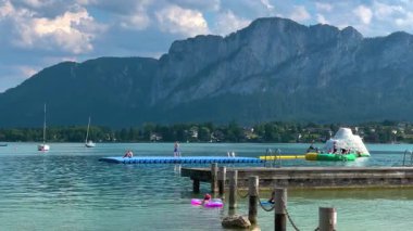 Mondsee, Yukarı Avusturya, 25 Haziran 2024: Ziyaretçiler, Mondsee kasabasındaki popüler bir göl kenti olan Alpenseebad Mondsee 'de güneşli bir yaz gününün tadını çıkarıyorlar