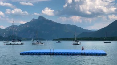 Mondsee, Yukarı Avusturya, 25 Haziran 2024: Ziyaretçiler, Mondsee kasabasındaki popüler bir göl kenti olan Alpenseebad Mondsee 'de güneşli bir yaz gününün tadını çıkarıyorlar