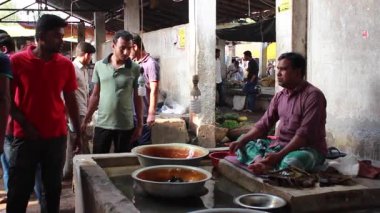 Bangladeş 'in önde gelen şehirlerinden biri olan Rangpur' daki Pouro Bazar pazarında kimliği belirsiz kişiler.