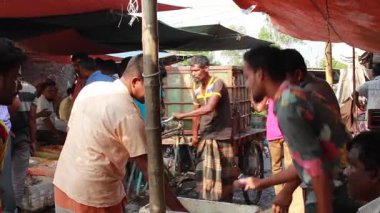 Bangladeş 'in önde gelen şehirlerinden biri olan Rangpur' daki Pouro Bazar pazarında kimliği belirsiz kişiler.