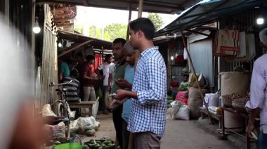 Bangladeş 'in önde gelen şehirlerinden biri olan Rangpur' daki Pouro Bazar pazarında kimliği belirsiz kişiler.