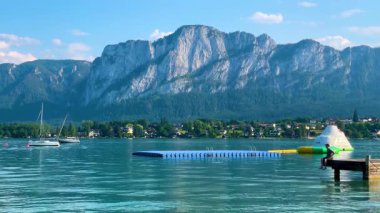 Mondsee, Yukarı Avusturya, 25 Haziran 2024: Ziyaretçiler, Mondsee kasabasındaki popüler bir göl kenti olan Alpenseebad Mondsee 'de güneşli bir yaz gününün tadını çıkarıyorlar