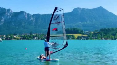 Mondsee, Yukarı Avusturya, 25 Haziran 2024: Ziyaretçiler, Mondsee kasabasındaki popüler bir göl kenti olan Alpenseebad Mondsee 'de güneşli bir yaz gününün tadını çıkarıyorlar