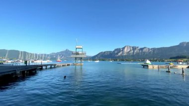 Mondsee, Yukarı Avusturya, 25 Haziran 2024: Ziyaretçiler, Mondsee kasabasındaki popüler bir göl kenti olan Alpenseebad Mondsee 'de güneşli bir yaz gününün tadını çıkarıyorlar