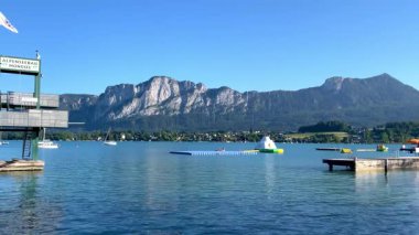 Mondsee, Yukarı Avusturya, 25 Haziran 2024: Ziyaretçiler, Mondsee kasabasındaki popüler bir göl kenti olan Alpenseebad Mondsee 'de güneşli bir yaz gününün tadını çıkarıyorlar