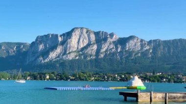 Mondsee, Yukarı Avusturya, 25 Haziran 2024: Ziyaretçiler, Mondsee kasabasındaki popüler bir göl kenti olan Alpenseebad Mondsee 'de güneşli bir yaz gününün tadını çıkarıyorlar